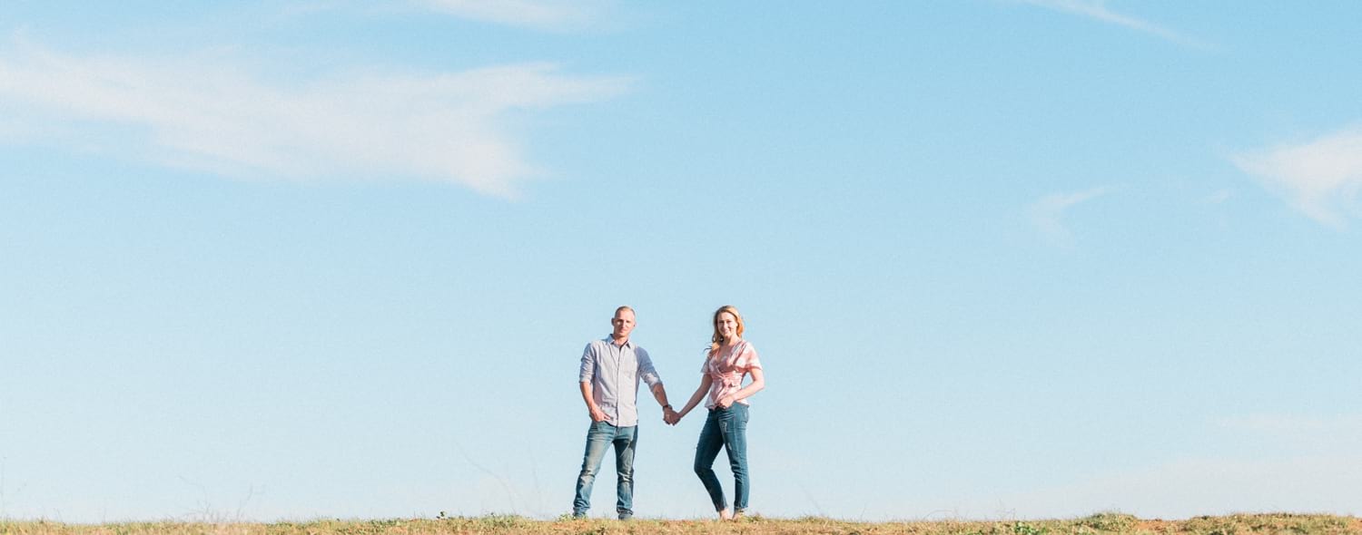 Couple holding hands on top of a hill in Fallbrook.