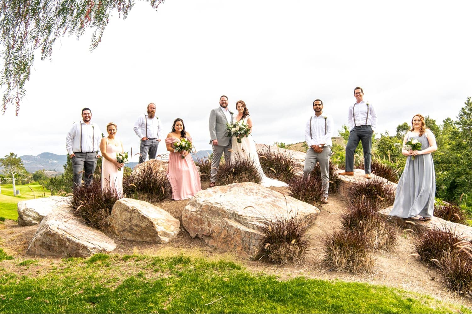 Bridal party standing on top of the rocks at Twin Oaks Golf Course. 