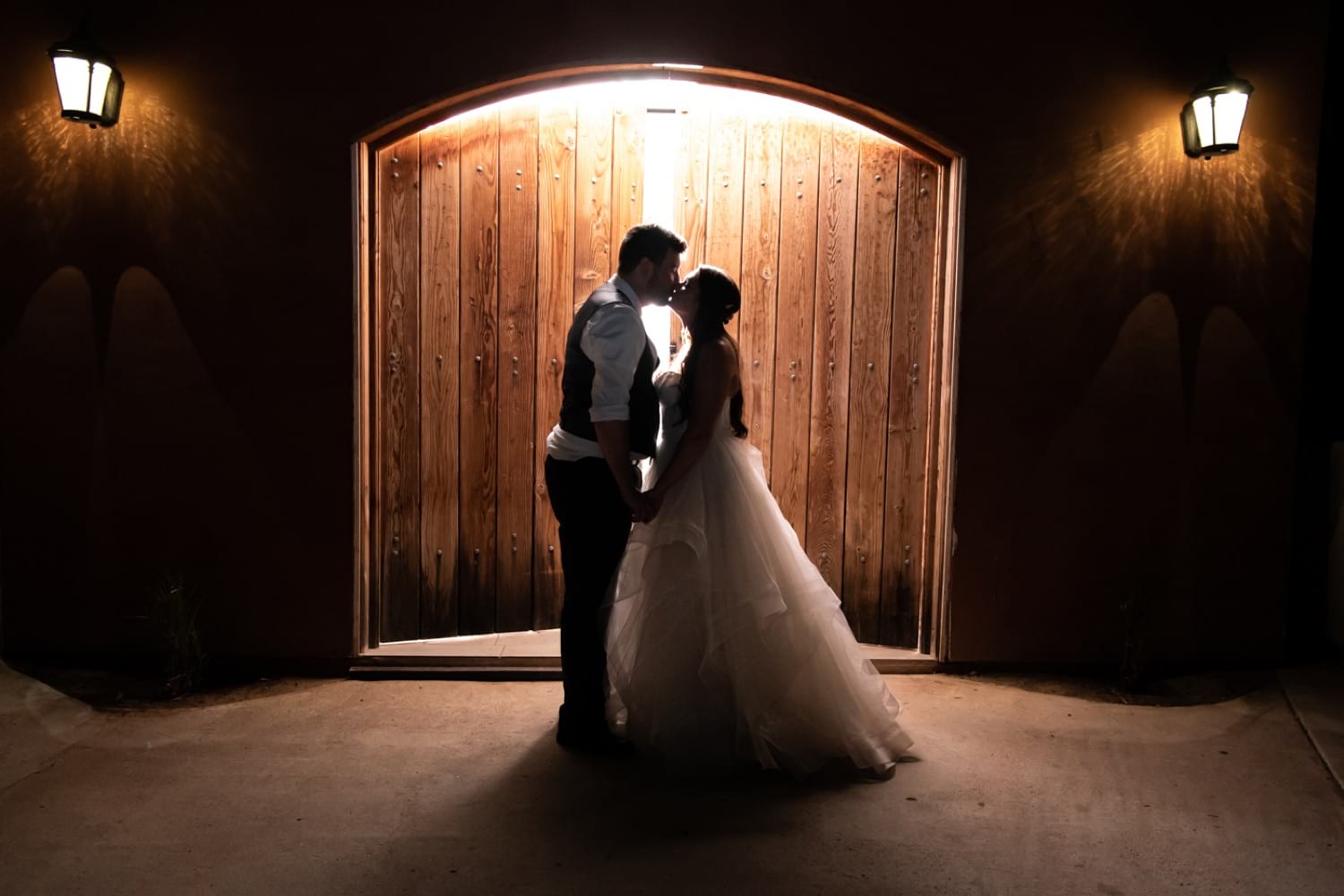 Bride kissing outside in the dark at Cordiano Winery. 